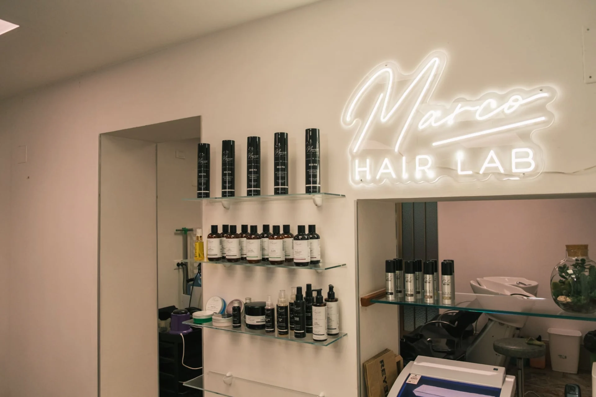 Insegna luminosa e prodotti nel salone Marco Hair Lab